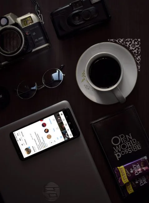 Un espace de travail moderne où des mains analysent des données marketing sur un ordinateur portable et des documents papier.